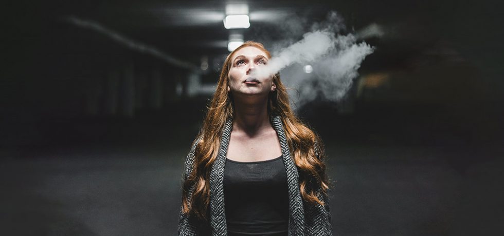 Woman Vaping in a Dark background