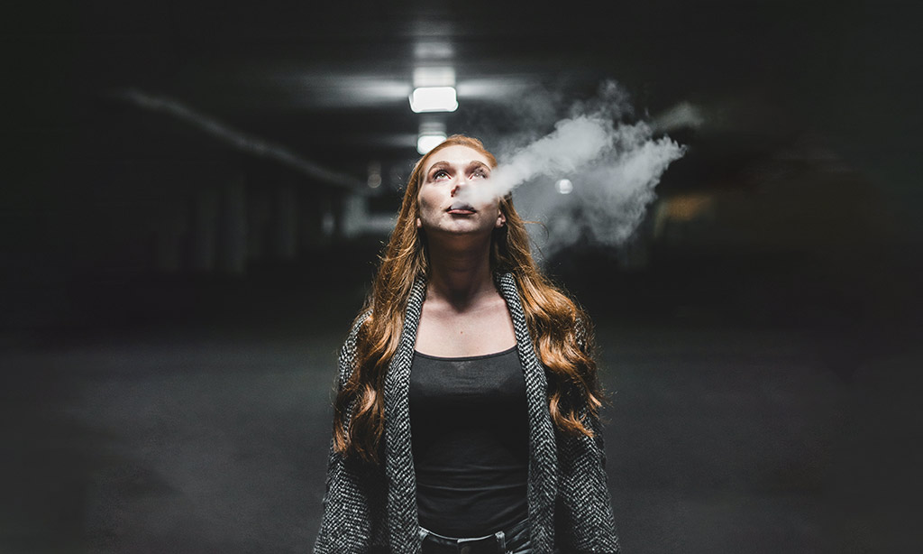 Woman Vaping in a Dark background