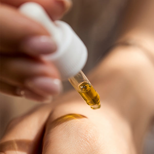 Woman Applying CBD Oil to Skin